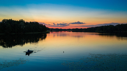 Lonely boat on lake in summer at sunset, aerial view