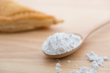  Close-up of tapioca starch or flour powder in wooden spoon with wooden background