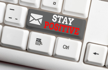 Conceptual hand writing showing Stay Positive. Concept meaning Engage in Uplifting Thoughts Be Optimistic and Real White pc keyboard with note paper above the white background