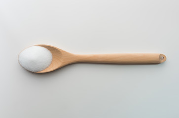 Top view of salt crystals powder on wooden spoon white background isolate with clipping path