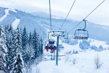 Fototapeta na wymiar Skiers on chairlift at ski resort
