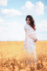 Pregnant woman in nature for a walk in the autumn