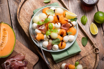 Melon, mozzarella, prosciutto appetizer or snack, summer salad with cantaloupe melon