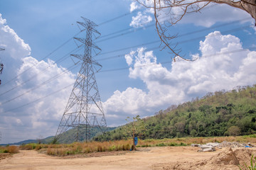 High voltage light poles in the open air on the background with the sky and mountains