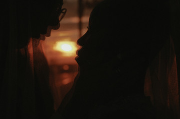 bride and groom covered with veil close-up. Interracial marriage. Asian bride and groom.