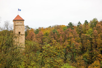 Main tower of old medieval castle Veveri surrounded by colorful autumn forest, Czech republic