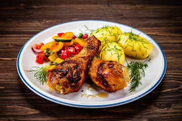 Grilled chicken drumsticks with boiled potatoes and vegetables