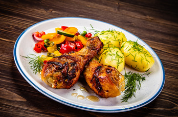 Grilled chicken drumsticks with boiled potatoes and vegetables