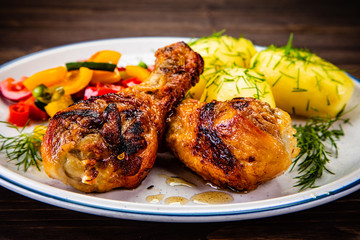 Grilled chicken drumsticks with boiled potatoes and vegetables
