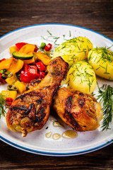 Grilled chicken drumsticks with boiled potatoes and vegetables