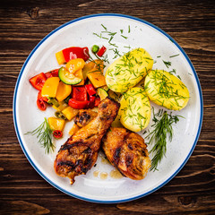 Grilled chicken drumsticks with boiled potatoes and vegetables