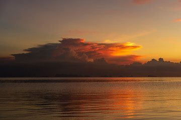 Naklejka premium Storm clouds during sunset.Colorful sunset over calm sea water near tropical beach. Summer vacation concept. Island Phangan, Thailand
