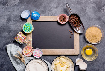 Baking ingredients for cake, cupcakes or muffins with chalk board copy space background