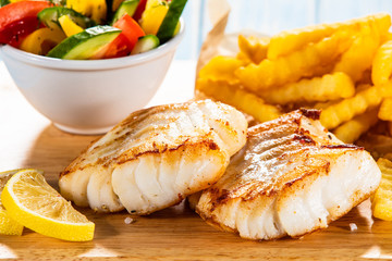 Fish dish - fried fish fillet with french fries and vegetables