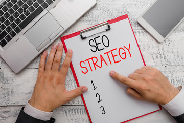 Writing note showing Seo Strategy. Business concept for Techniques and tactics to increase the...