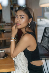 Fototapeta na wymiar Asian smile girl in a cafe. Beautiful Balinese women with a cup of coffee