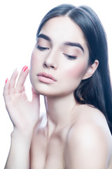 Obraz na płótnie Canvas Beauty studio portrait of young woman with perfect skin touching face. Nude natural make-up, naked shoulder. Apply cream cosmetics. White background. Facial treatment skincare health concept