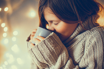 girl child in sweater with cup, cozy , toning