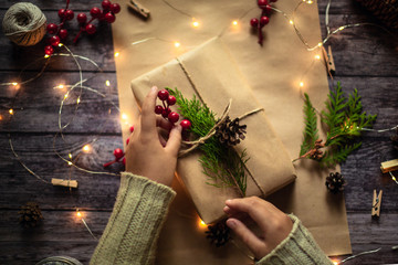 hands wrapping gift in craft paper, christmas mood