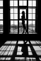 Schwarz-Weiß-Porträt einer sexy, schönen jungen Dame über hellem Fensterhintergrund © spritnyuk