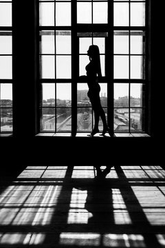 Black and white portrait of sexy beautiful young lady over light window background