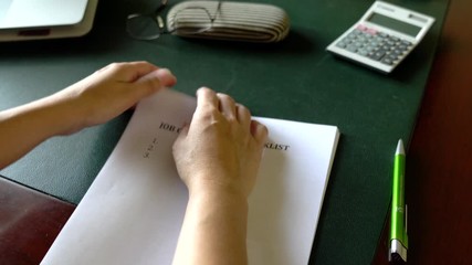 Onboarding process concept, going through the job orientation checklist with office desk as background