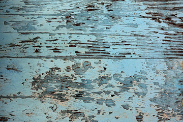 Grunge background of peeling blue paint on old wooden board