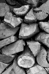 A pile of cut firewood abstract texture. Lots of stacked wooden logs piling, tightly alligned. Wallpaper, background, repetitive pattern. Lumber, timber concept. Horizontal shot, wall of wood
