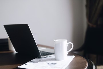 laptop and cup of coffee on table