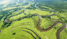 Aerial landscape of winding river in green fields