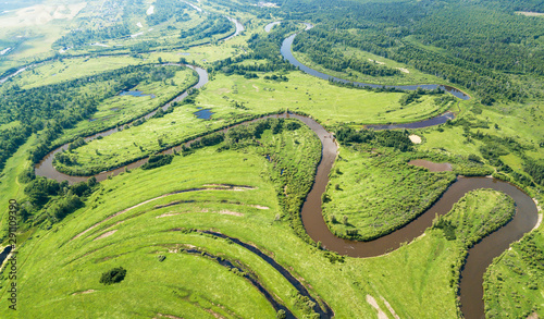 Aerial landscape of winding river in green fields