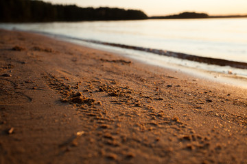 Tire marks in the sand. Wheel marks on the beach. Evening beach, sand with traces. Photo background with beach and tire tracks