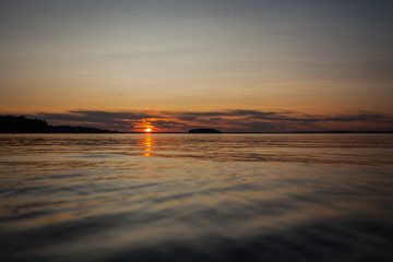 Obraz na płótnie Canvas Sunset on the coast. Beautiful sunset, sun and water.