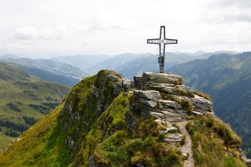 Cross at the top of Tristkogel mountain in Austria during summer