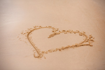 Heart. Drawing a heart on the sand. Finger drawing, heart - photo background with copy-space on the theme of love, relationships, romance, family, wedding and Valentine's day.