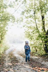 Fototapeta na wymiar little boy alone in autumn outdoors in the park