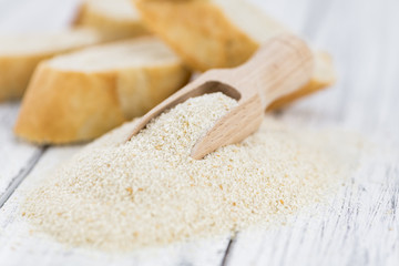 Breadcrumbs on a wooden spoon (close-up shot; selective focus)
