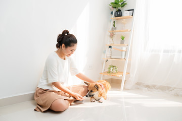 Young Asian woman playing with her dog at home