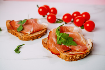 slice of bread with smoked ham and tomato on a white background