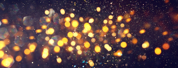 Obraz na płótnie Canvas background of abstract glitter lights. gold and black. de focused. banner