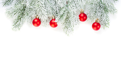 Fototapeta na wymiar Green fir branch and red glass baubles isolated on white background. Christmas decorations border