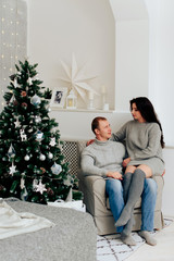 young couple in love in christmas decor with gifts and christmas tree