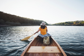 Rear view of woman paddling canoe. Paddling, canoeing, outdoors, adventure