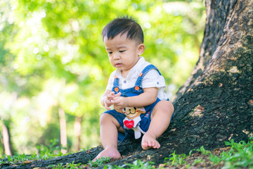 Kid child boy enjoying with nature green grass under tree