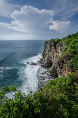 Fototapeta na wymiar View Of The Cliff And Balinese Sea with white cloud and beautiful sky on the way to Uluwatu Temple