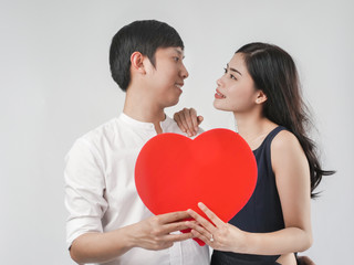 Fototapeta na wymiar Happy couple in love holding red heart shape, valentine concept.