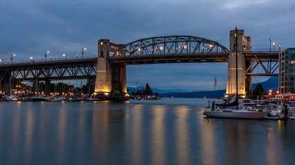 Burrard Bridge, Vancouver, Canada, at dusk, with the lights of the bridge reflecting in the water