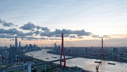 Shanghai Skyline at sunset. Shanghai cityscape, Huangpu river and Yangpu bridge with cloudy sky, Panoramic Aerial View.