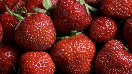 Sideways movement along ripe strawberries. Close up, natural background. Camera moves sideway to the left side. 4K - 50fps 