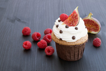 Chocolate cake with figs and raspberries on a black background.
